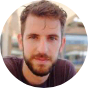 Man with beard in dark shirt, blurred background