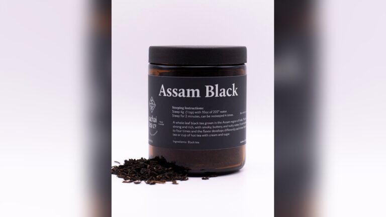 Assam Black tea in a jar with loose tea leaves spilling out