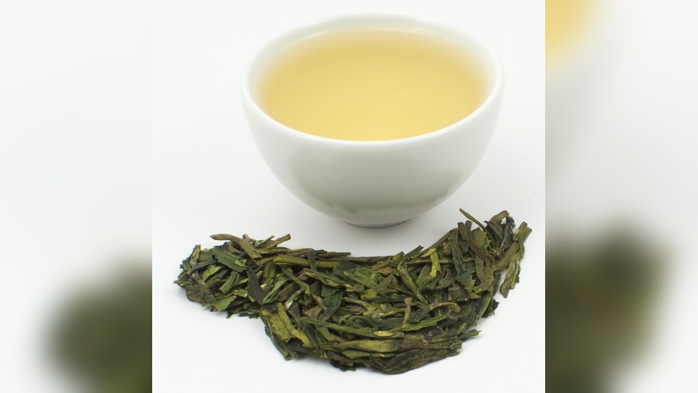 Dragon Well tea leaves and brewed tea in a white cup