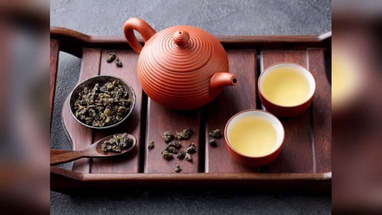Oolong tea set with terracotta teapot, cups, and loose leaves