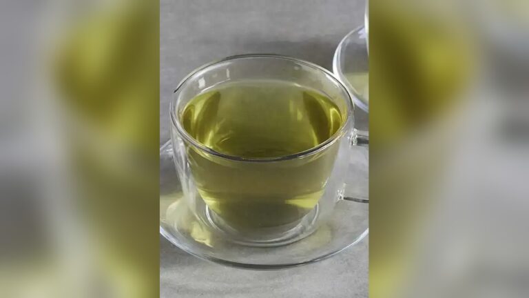 Glass cup of Lipton green tea on a saucer