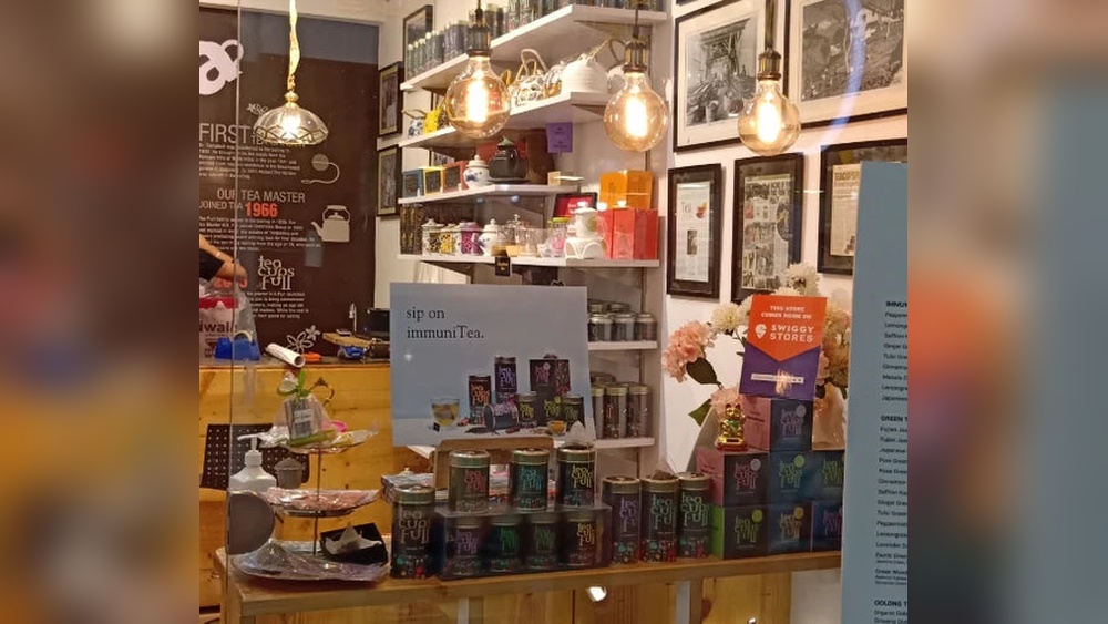 Tea shop display with various tea tins, boxes, and light bulbs