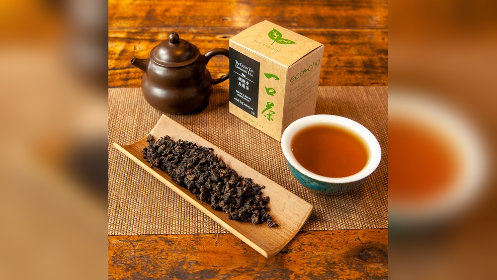 Tieguanyin Oolong tea leaves, teapot, and cup with EcoCha box