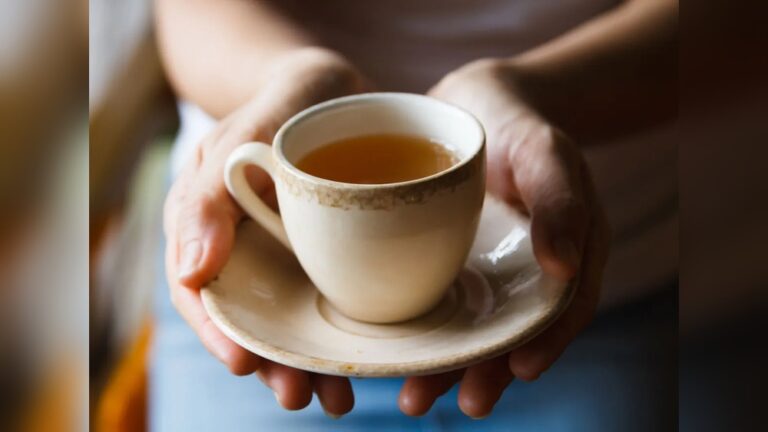 Hands holding a cup of tea, relevant to tea and coffee consumption.