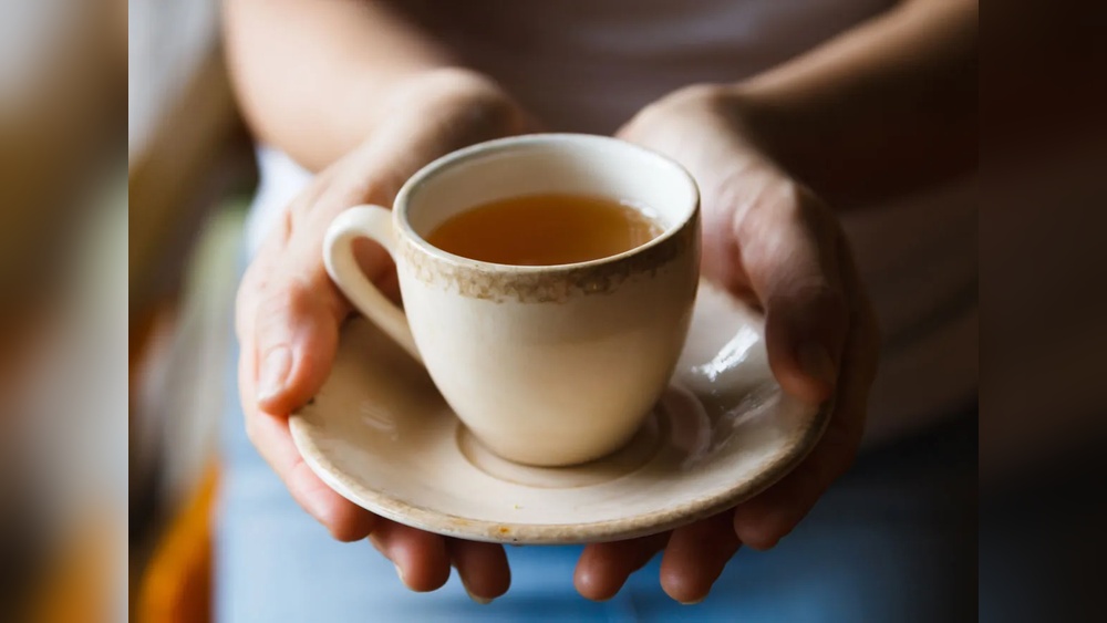 Hands holding a cup of tea, relevant to tea and coffee consumption.