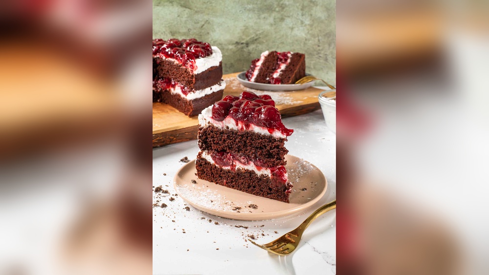 Rich chocolate Black Forest cake with whipped cream and cherries